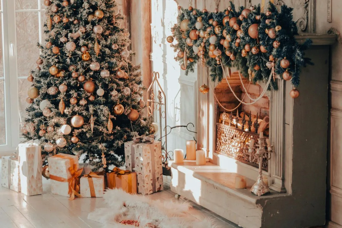 cozy christmas living room with a decorated tree, wrapped gifts, and a garland-covered fireplace glowing with candles