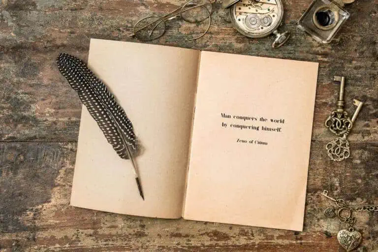 open vintage book with a feather quill and a quote by zeno of citium on a rustic wooden table surrounded by antique keys, glasses, and a pocket watch