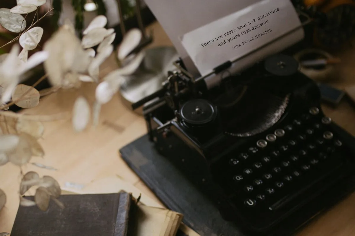 vintage black typewriter on a wooden desk with Zora Neale Hurston's quote typed on paper that reads 'there are years that ask questions and years that answer