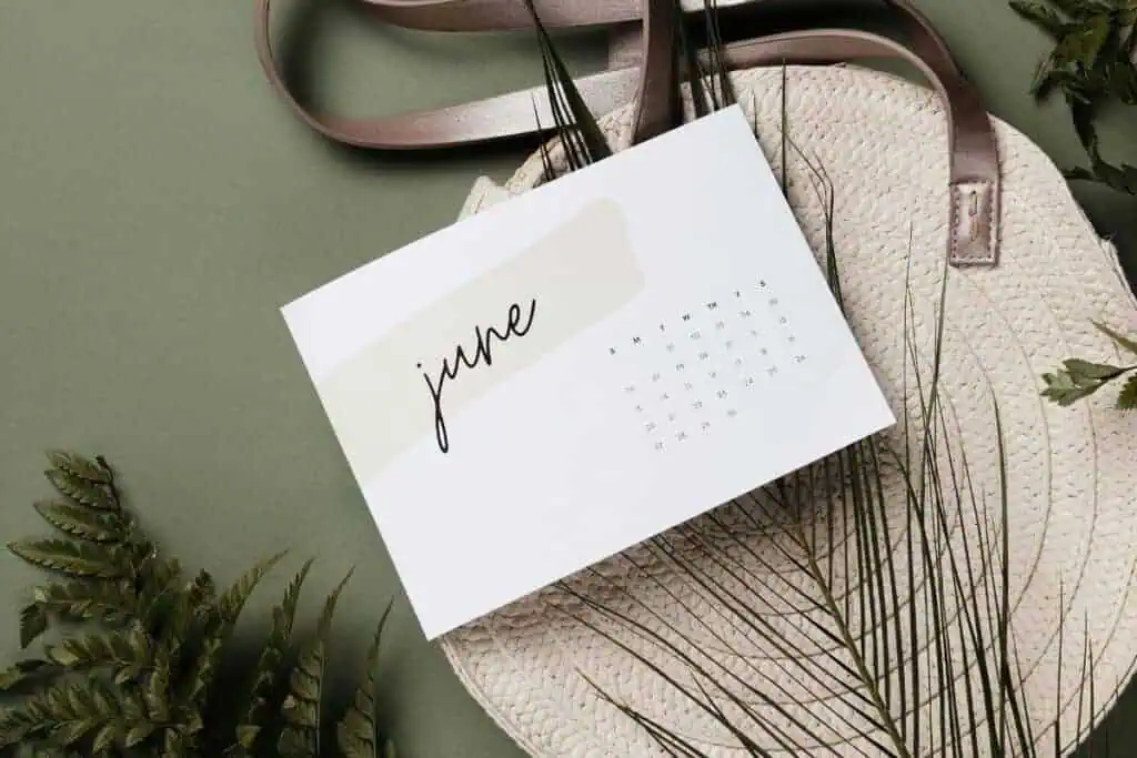 a featured image for the june quotes post showing minimal june calendar on a woven bag with green leaves and soft shadows