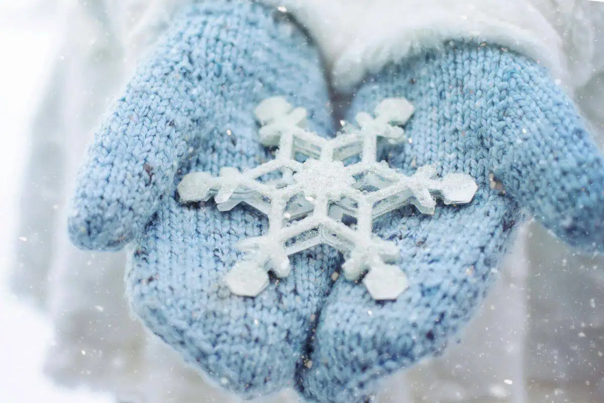 blue mittens holding a snowflake