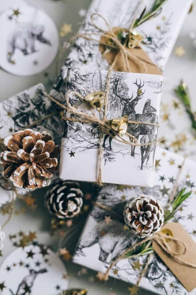 : beautifully wrapped christmas gifts with pinecones, golden stars, and twine on a festive winter table