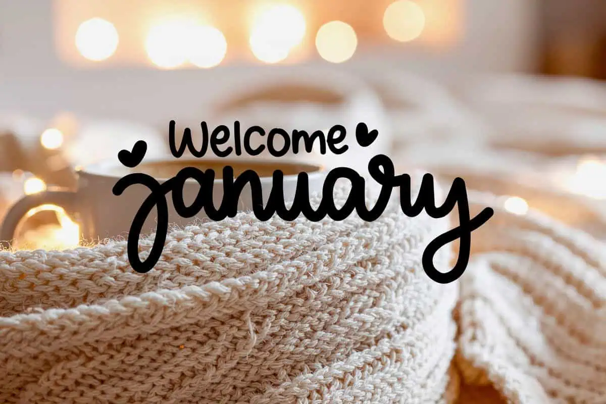 cozy winter scene with coffee cup wrapped in knitted blanket and welcome january text
