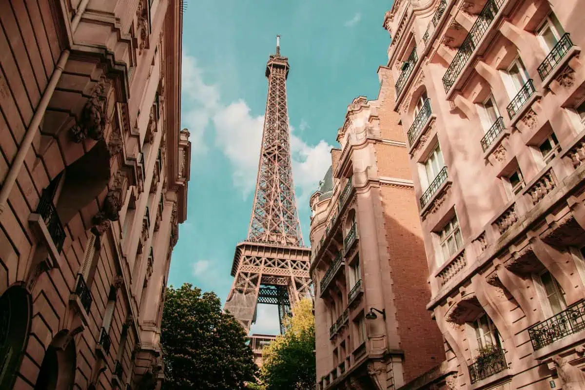 eiffel tower framed by parisian buildings on a quiet street